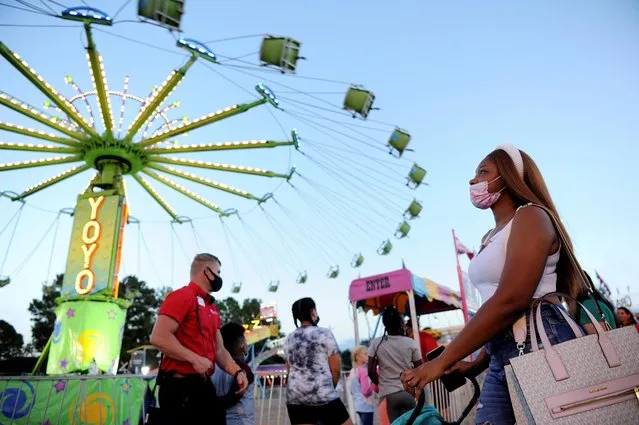 Miyana Moffett watches a ride at the Mississippi State Fair as it opens with coronavirus disease (COVID-19) restrictions in Jackson, Mississippi, U.S., October 7, 2020. (Photo by Rory Doyle/Reuters)