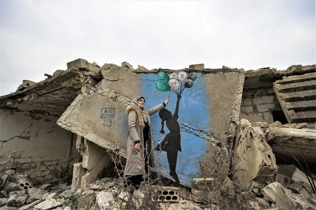 Female graffiti artist Selam Hamid is seen with his made graffiti paintings on the walls of buildings damaged by bombing by the Bashar Assad regime in Idlib, Syria on January 08, 2023. Hamid paints on damaged walls the attacks, massacres, arrests and migration events organized by the Bashar Assad regime, Iran-backed terrorist groups and Russia. (Photo by Esra Hacioglu Karakaya/Anadolu Agency via Getty Images)