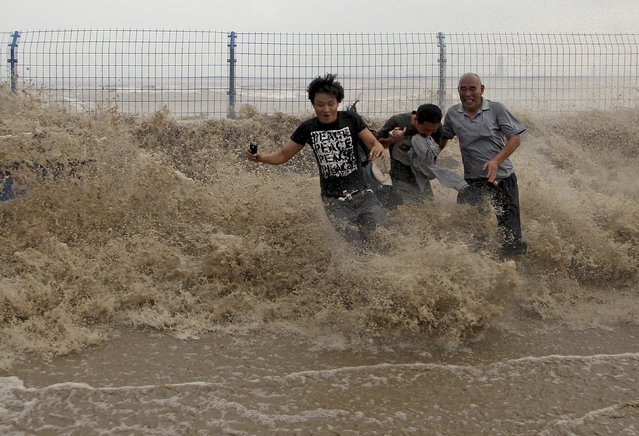 Visitors run from waves caused by a tidal bore as it surges past a barrier on the banks of Qiantang River, in Hangzhou Zhejiang province, September 21, 2013. (Photo by Reuters/Stringer)