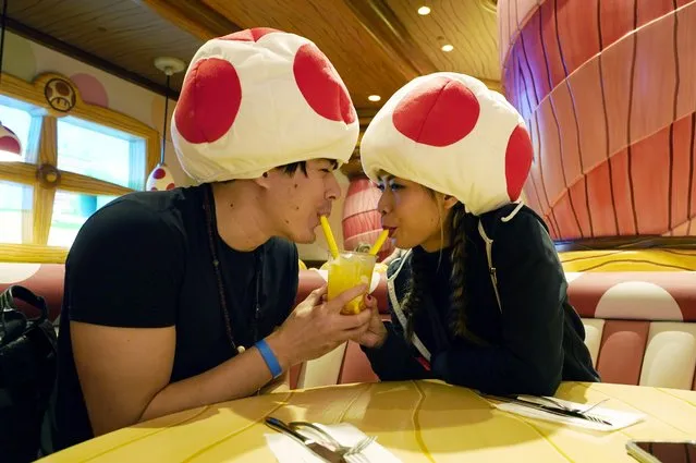 David Valenzuela, left, and Sulhee Jessica Woo of Las Vegas wear mushroom caps as they share a drink at the Toadstool Cafe in the new Universal Studios Hollywood attraction Super Nintendo World during a preview day, Thursday, February 16, 2023, in Universal City, Calif. The attraction opens to the public Friday. (Photo by Chris Pizzello/AP Photo)