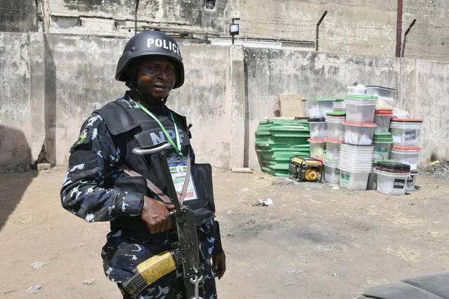 An anti riot Police officer stands meters away from ballot boxes used during the presidential elections at the state headquarters of Independent National Electoral Commission (INEC) in Yola on February 26, 2023 the day after Nigeria's presidential and general election. (Photo by Pius Utomi Ekpei/AFP Photo)