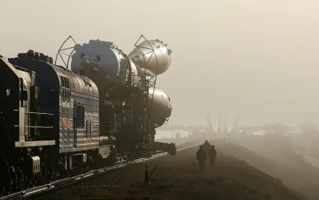 Security personnel escort the Soyuz MS-08 spacecraft for the next International Space Station (ISS) crew, consisting of astronauts Drew Feustel and Ricky Arnold of the U.S and crewmate Oleg Artemyev of Russia, as it is transported from an assembling hangar to the launchpad ahead of its upcoming launch, at the Baikonur Cosmodrome, Kazakhstan March 19, 2018. (Photo by Shamil Zhumatov/Reuters)