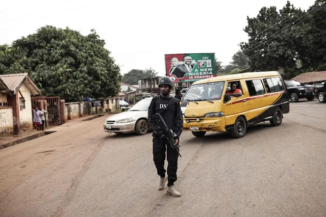 A Department of State Services (DSS) official stands guard a polling station in Amatutu on February 25, 2023, during Nigeria's presidential and general election. (Photo by Patrick Meinhardt/AFP Photo)