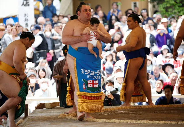 Georgian sumo wrestler Gagamaru carries a baby in a sumo ring during an annual sumo tournament dedicated to the Yasukuni Shrine in Tokyo, Japan on April 16, 2018. (Photo by Toru Hanai/Reuters)