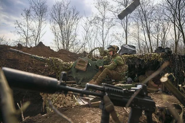 An Ukrainian serviceman sits on an anti-air gun near Bakhmut, on March 24, 2023. (Photo by Aris Messinis/AFP Photo)