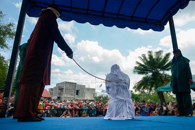 A woman is publicly flogged in front of a mosque in the provincial capital Banda Aceh on April 20, 2018. (Photo by Chaideer Mahyuddin/AFP Photo)