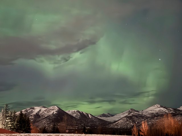 The northern lights appear over the Chugach Mountains on the eastern edge of Anchorage, Alaska, on Monday, March 24, 2025. (Photo by Mark Thiessen/AP Photo)