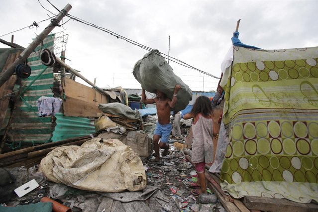 A Filipino man carries a bag of scraps at a dumpsite in Manila, Philippines on Thursday, January 8, 2015. (Photo by Aaron Favila/AP Photo)
