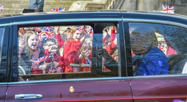 School kids scream and wave flags during King Charles III visit to Liverpool, United Kingdom on April 26, 2023. (Photo by Peter Powell)