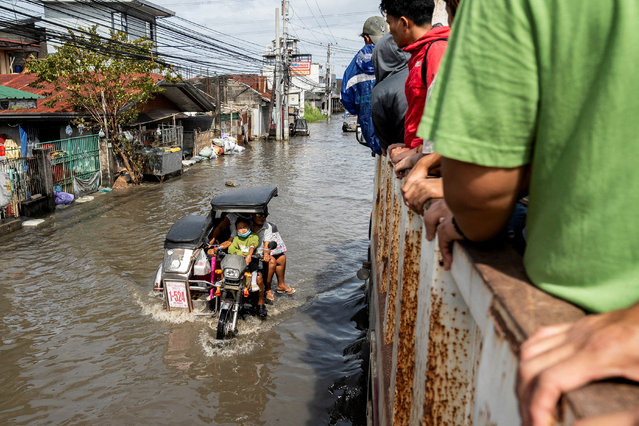 People ride a motorbike with a sidecar as it wades through a flooded road following flooding brought by high tide and Super Typhoon Fung-wong, in Macabebe town, Pampanga province, Philippines, on November 10, 2025. (Photo by Lisa Marie David/Reuters)