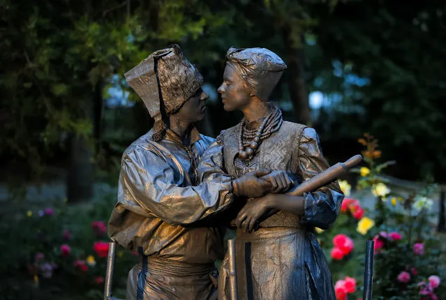 In this Thursday, May 24, 2018, photograph, artists of Ukraine's Artel Myth theatre perform “A day in the life of Ukrainians” at the Living Statues International Festival, in Bucharest, Romania. (Photo by Vadim Ghirda/AP Photo)