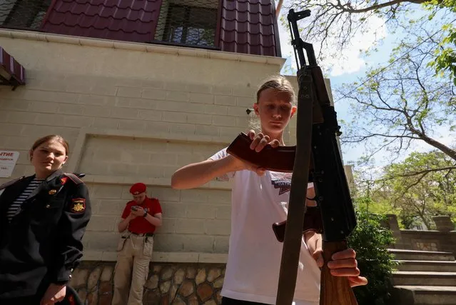 Members of Russia's Youth Army military-patriotic movement and other participants attend a demonstration lesson that is part of an extracurricular educational program, which involves weapon training, first aid treatment, camping skills and other courses, in Sevastopol, Crimea on May 19, 2023. (Photo by Alexey Pavlishak/Reuters)