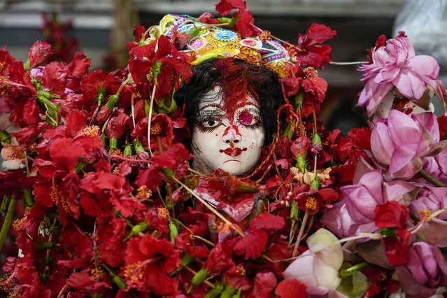 A clay image of Hindu deity Ganga, under the heap of garlands, is seen during Ganga Dussehra festival on the banks of Hooghly River, a branch of the Ganges, in Kolkata, India, Tuesday, May 30, 2023. River Ganges is considered the most sacred and the holiest river for Hindus. (Photo by Bikas Das/AP Photo)