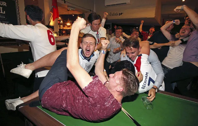 England supporters celebrate Harry Kane's winning goal as fans watch the World Cup soccer match between Tunisia and England at the Lord Raglan Pub in London, Monday, June 18, 2018. (Photo by Nigel French/PA Wire via AP Photo)