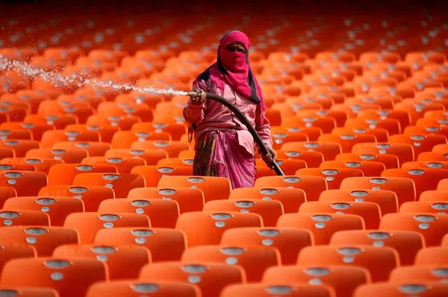 A worker cleans the seats in the stands at Sardar Patel Gujarat Stadium, where India and England are scheduled to play their third test match, in Ahmedabad India, February 17, 2021. (Photo by Amit Dave/Reuters)