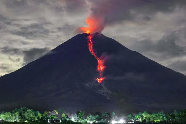 In this picture taken on January 16, 2021, lava is seen during an eruption of Mount Semeru in Lumajang, East Java, Indonesia. (Photo by Agus Harianto/AFP Photo)