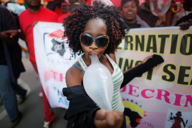 A Kenyan female s*x worker plays with an inflated condom as she walks with supporters and members of the lesbian, gay, bisexual and transgender (LGBT) community to mark the International Day to End Violence Against s*x Workers in downtown Nairobi, Kenya, 17 December 2015. Hudreds of s*x workers gathered to demand decriminalization of s*x workers in the country and to give them more rights and protection. (Photo by Dai Kurokawa/EPA)