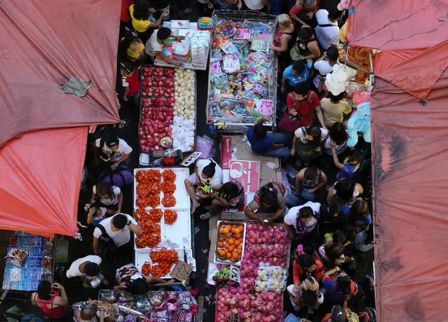 Filipino vendors sells fruits and toys as people shop for Christmas gifts in downtown Manila, Philippines on Wednesday, December 23, 2015. Christmas is one of the most important holidays in this predominantly Roman Catholic nation. (Photo by Aaron Favila/AP Photo)