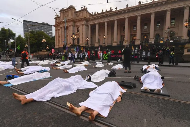 Protesters are seen during an extinction Rebellion protest outside the Victorian State Parliament in Melbourne, Australia, 22 March 2021. Activist group Extinction Rebellion is holding a range of events in Australian capital cities, encouraging action on climate and environmental issues. (Photo by James Ross/EPA/EFE)