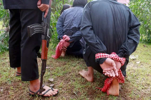 A scene from the notorious “Killing Fields” is re-enacted during a ceremony at the Choeung Ek Genocidal Center on the outskirts of Phnom Penh, Cambodia, 20 May 2022. Cambodians mark the annual National Day of Remembrance, also known as the Day of Anger, to commemorate the victims who died during the rule of the Khmer Rouge regime from 1975-1979. Around two million Cambodians are estimated to have died from starvation and forced labor or were killed in politically-justified executions during the Khmer Rouge regime. (Photo by Kith Serey/EPA/EFE)