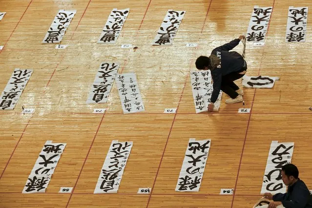 Staff collect sheets with calligraphy during a contest celebrating the New Year in Tokyo January 5, 2016. Over 3,000 calligraphers who qualified in competitions throughout Japan wrote resolutions or wishes onto paper sheets during the annual contest that marks the start of the new year, according to organizers. (Photo by Thomas Peter/Reuters)
