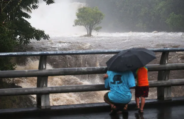 People gather on a bridge to watch the Wailuku River flood waters on the Big Island on August 23, 2018 in Hilo, Hawaii. Hurricane Lane has brought more than a foot of rain to some parts of the Big Island which is under a flash flood warning. (Photo by Mario Tama/Getty Images)