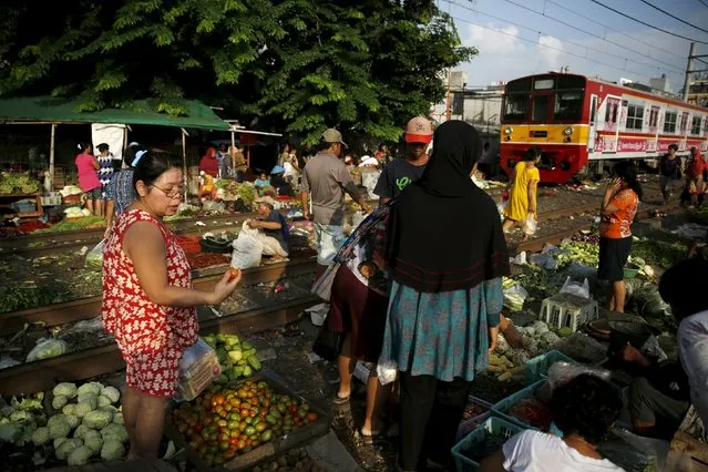 Customers shop at Duri market on a railway track in Jakarta, January 8, 2016. Indonesia's annual inflation rate cooled to the lowest in six years in December, which might pave the way for the central bank to cut a benchmark rate held at 7.50 percent since February 2015. (Photo by Reuters/Beawiharta)