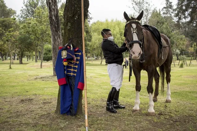 A presidential guard gets ready for the inauguration ceremony of President-elect Guillermo Lasso at the National Assembly in Quito, Ecuador, Monday, May 24, 2021. (Photo by Carlos Noriega/AP Photo)