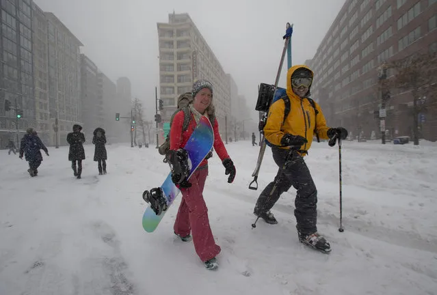 Kristin Maruszewski, left, and Tom Yost, walk home from a day of skiing and snowboarding, taking advantage of the snowy weather in Washington, Saturday, January 23, 2016. (Photo by Manuel Balce Ceneta/AP Photo)