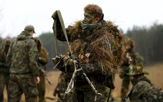 Damian Trynkiewicz carries his weapon during territorial defence training organised by SJS Strzelec (Shooters Association), paramilitary group in the forest near Minsk Mazowiecki, eastern Poland March 14, 2014. (Photo by Kacper Pempel/Reuters)