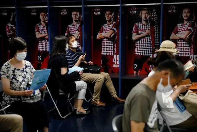People wait for consultation after receiving doses of the coronavirus vaccine at the players' locker room of Japanese professional soccer club Vissel Kobe inside Noevir Stadium Kobe, currently acting as a large-scale COVID-19 vaccination center, in Kobe, Japan on June 12, 2021. (Photo by Issei Kato/Reuters)