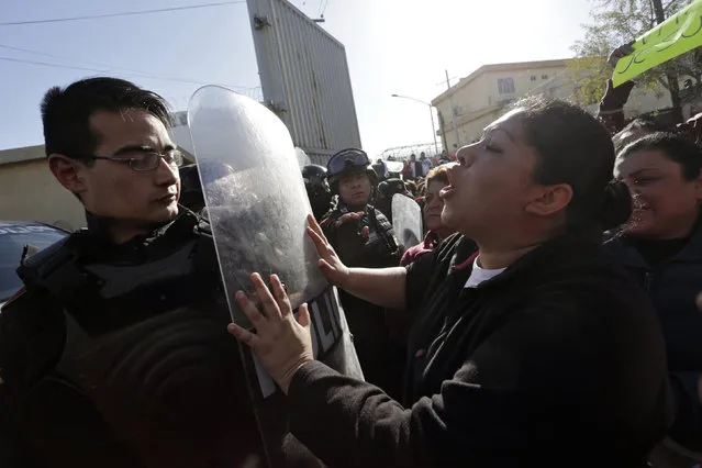 A family member of an inmate pushes the shield of a police officer outside the Topo Chico prison in Monterrey, Mexico, February 11, 2016. (Photo by Daniel Becerril/Reuters)