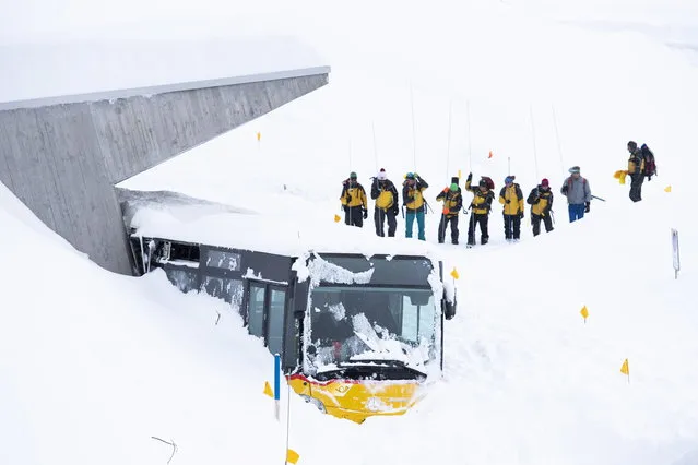 A bus caught by an avalanche next to Hotel Saentis, with search-and-rescue workers, on the Schwaegalp, Switzerland, in Hundwil, Switzerland, 11 January 2019. According to local police, an avalanche has hit the the hotel “Saentis” on 10 January afternoon, burrying cars and part of the restaurant. Several people were injured, the report stated. (Photo by Gian Ehrenzeller/EPA/EFE)