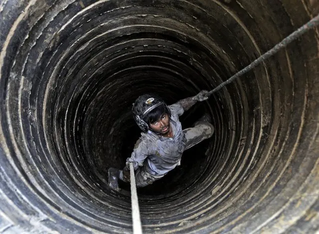 Nepalese worker Deepak Kumal, 27, hangs on a rope as he digs in well for a water source in Kathmandu, Nepal, 22 March 2015. On the backdrop of rapid urban population growth, industrialization and uncertainties caused by climate change, Kathmandu has been facing water crises during winter and spring seasons. International World Water Day is marked on 22 March annually focusing importance of freshwater. (Photo by Narendra Shrestha/EPA)