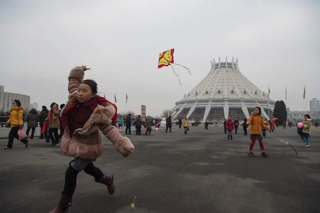 A girl flies a kite as North Koreans come out to mark the start of 2017 on New Year's Day in Pyongyang on January 1, 2017. (Photo by Kim Won-Jin/AFP Photo)