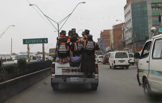 In this December 13, 2013 photo, Aymara traffic policewomen are transported to a checkpoint to help control and direct traffic in El Alto, Bolivia. (Photo by Juan Karita/AP Photo)