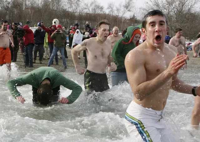 Participants in the 6th annual Polar Bear Dip & Dash run from the East End Beach into Casco Bay in Portland, Maine, December 31, 2013. According to the National Oceanic and Atmospheric Administration (NOAA), the water temperature in Portland is 42.4 degrees Fahrenheit and the air temperature is 9 degrees Fahrenheit. (Photo by Joel Page/Reuters)