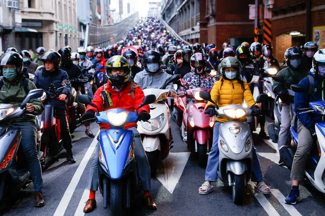 People on motorbikes wait at a traffic light during morning rush hour in Taipei, Taiwan on January 10, 2024. (Photo by Ann Wang/Reuters)