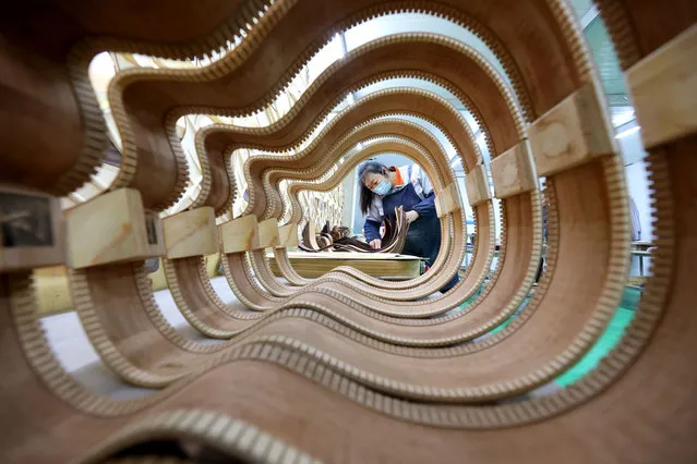 A worker makes guitar at a musical instrument manufacturing enterprise on January 4, 2024 in Zaozhuang, Shandong Province of China. (Photo by Sun Zhongzhe/VCG via Getty Images)