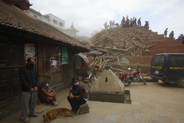 A Nepalese man stands with his dog as rescue workers remove debris at Durbar Square after an earthquake in Kathmandu, Nepal, Saturday, April 25, 2015. (Photo by Niranjan Shrestha/AP Photo)