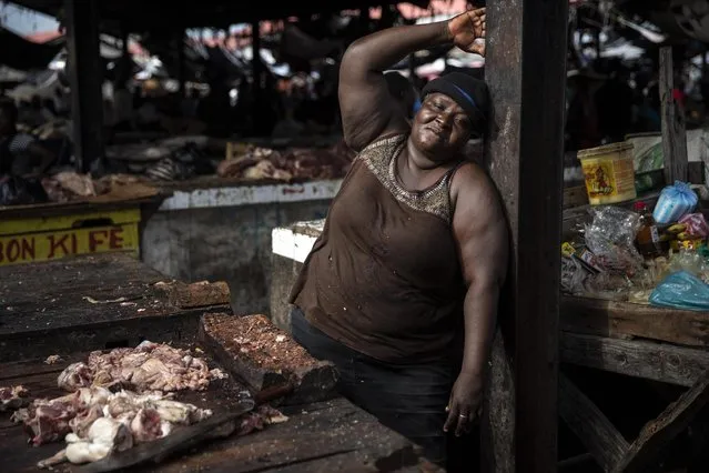 Vendor Celestine poses for a photo while taking a break in her butcher stand in a popular market in downtown Port-au-Prince, Haiti, Wednesday, September 22, 2021. (Photo by Rodrigo Abd/AP Photo)