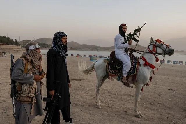 A Taliban fighter rides a horse as he and others take a day off to visit the amusement park at Kabul's Qargha reservoir, at the outskirts of Kabul, Afghanistan on October 8, 2021. (Photo by Jorge Silva/Reuters)