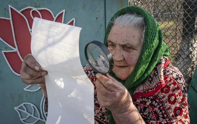 An elderly woman examines her ballot voting at home during the presidential election in Mariinka, near a contact line not far from Donetsk, eastern Ukraine, Sunday, March 31, 2019. Ukrainians choose from among 39 candidates for a president they hope can guide the country of more than 42 million out of troubles including endemic corruption, a seemingly intractable conflict with Russia-backed separatists in the country's east and a struggling economy. (Photo by Evgeniy Maloletka/AP Photo)