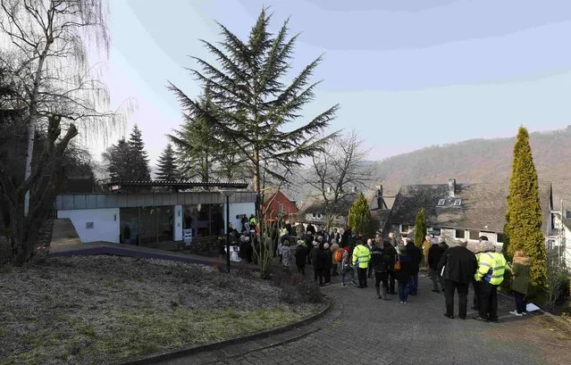 People wait outside a Federal Reserve bank (Bundesbank) bunker prior to the bunker's official opening to the public in Cochem, Germany, March 18, 2016. (Photo by Kai Pfaffenbach/Reuters)