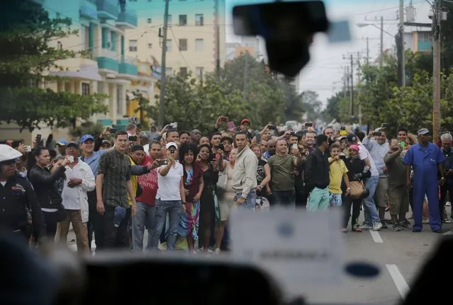 Cubans line the road to see the motorcade of U.S. President Barack Obama as he is driven to the first meeting with Cuban's President Raul Castro on the second day of Obama's visit to Cuba, in Havana March 21, 2016. (Photo by Carlos Barria/Reuters)
