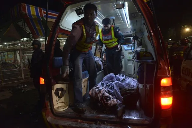 Pakistani rescuers carry a body in an ambulance from a bomb blast site in Lahore on March 27, 2016. At least 25 people were killed and dozens injured when an explosion ripped through the parking lot of a crowded park where many minority Christians had gone to celebrate Easter Sunday in the Pakistani city Lahore, officials said. (Photo by Arif Ali/AFP Photo)