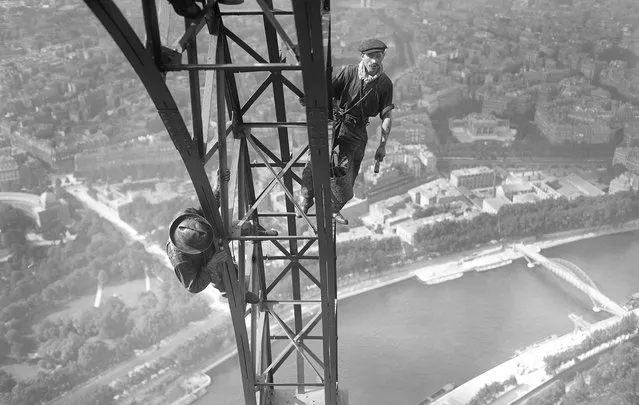 (Original Caption) 7/29/1924. Paris, France. Men at work high above ground, painting the Eiffel Tower. (Phoot by Bettmann Archive)