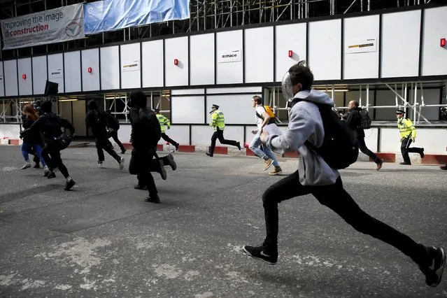 Protesters run during a demonstration against the Conservative Party in central London, May 9, 2015. Protesters threw bottles, cans and smoke bombs at riot police in central London on Saturday in a demonstration against the re-election of Britain's Conservative Prime Minister David Cameron. (Photo by Stefan Wermuth/Reuters)