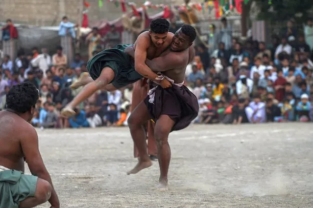 Wrestlers compete during a traditional Sindhi Malakhra wrestling during a local tournament in Pakistan's port city of Karachi on December 3, 2021. (Photo by Rizwan Tabassum/AFP Photo)