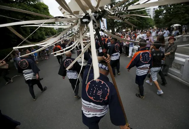 Men wearing costume of traditional firefighters swing"Matoi"company standards, following a memorial service for firefighters at Sensoji temple in Tokyo's downtown of Asakusa May 25, 2015. (Photo by Issei Kato/Reuters)